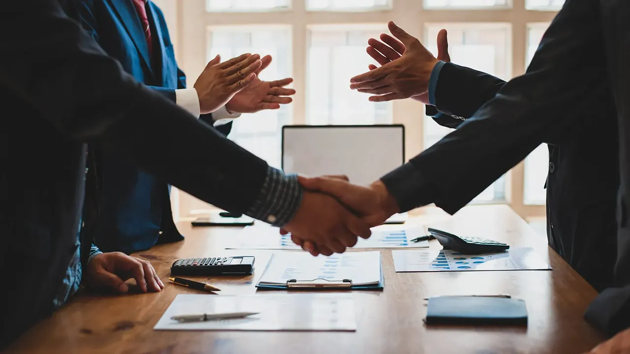 دو نفر درحال دست دادن به هم نمادی از تسهیل معاملات توسط مشاورین املاک