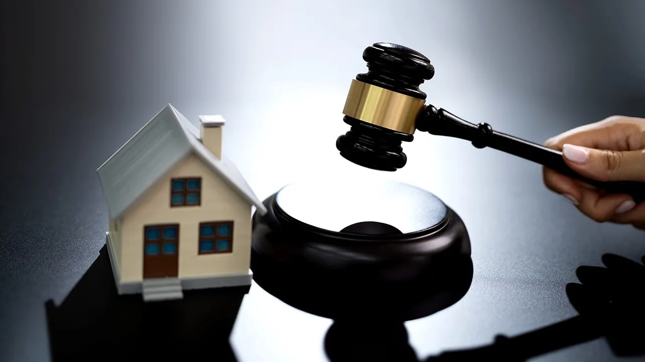 تصویر ماکت یک خانه که در کنار آن قاضی با چکش عدالت ضربه میزند و نمادی از صدور حکم است 