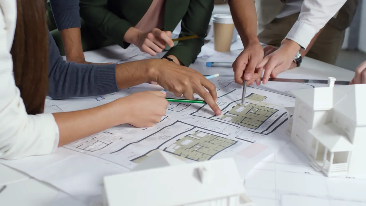 گروهی از اعضای شرکت معماری در حال کار کردن روی یک پروژه معماری